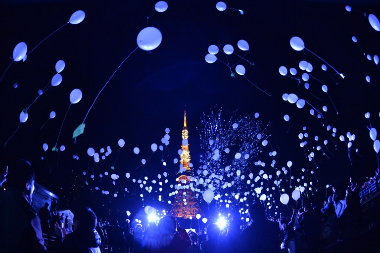 People release balloons to celebrate the New Year at the Prince Park Tower in Tokyo on January 1, 2016. More than 1,000 balloons were released, carrying with them new year wishes. / AFP / KAZUHIRO NOGI