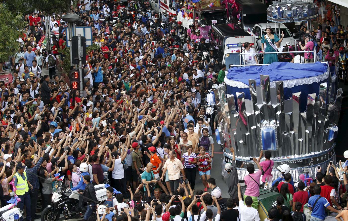 Miss Universe 2015 Pia Alonzo Wurtzbach waves to the crowd as her motorcade passes along a busy street in Manila, January 25, 2016. Wurtzbach, the first Miss Universe from the Philippines in more than four decades, said on Sunday she will spend her reign bringing awareness to issues like HIV and draw support for countries vulnerable to disasters.  REUTERS/Erik De Castro