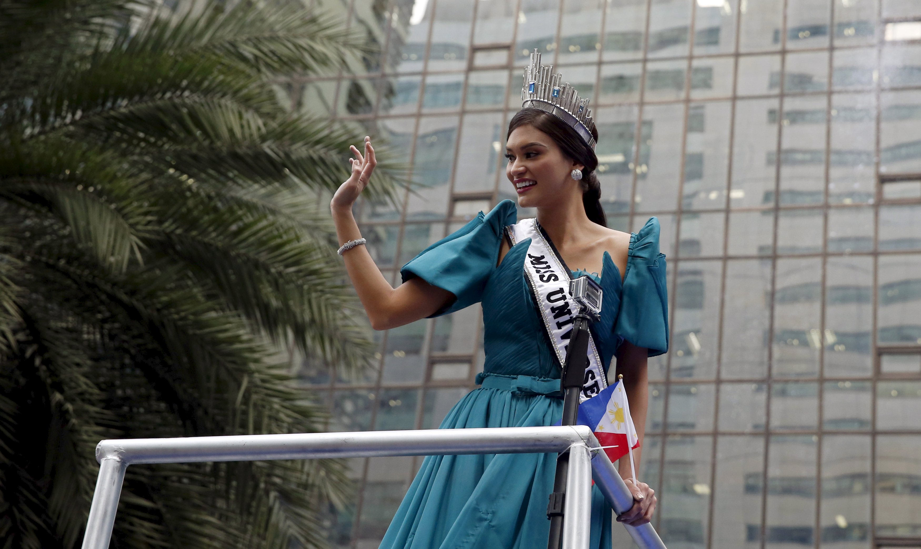 Miss Universe 2015 Pia Alonzo Wurtzbach waves to fans as her motorcade passes along Ayala Avenue in Manila's Makati financial district, January 25, 2016. Wurtzbach, the first Miss Universe from the Philippines in more than four decades, said on Sunday she will spend her reign bringing awareness to issues like HIV and draw support for countries vulnerable to disasters.  REUTERS/Erik De Castro