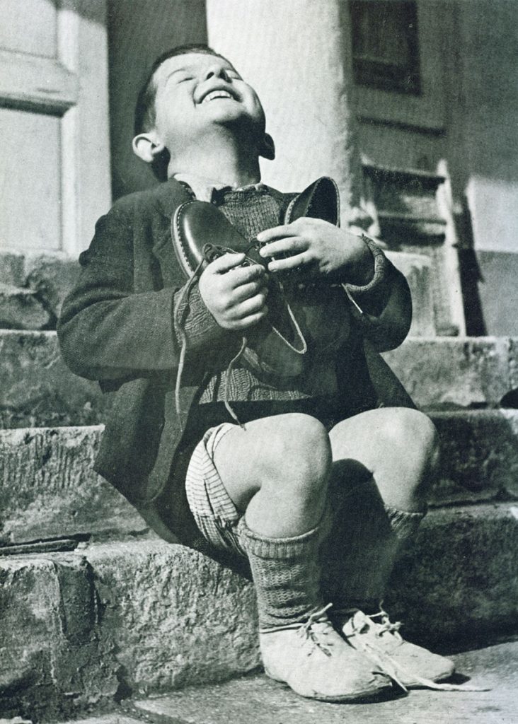 3. Niño austriaco recibiendo unos zapatos nuevos durante la 2ª Guerra Mundial