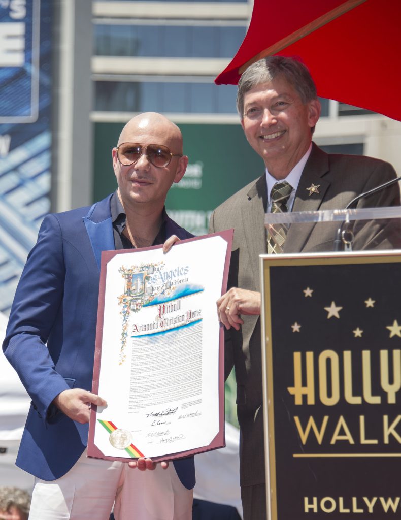 Singer Pitbull (L) and Hollywood Chamber of Commerce President/CEO Leron Gubler pose at the ceremony honoring Pitbull with a star on the Hollywood Walk Of Fame, California, on July 15, 2016. / AFP PHOTO / VALERIE MACON