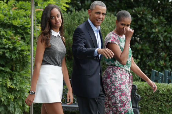 WASHINGTON, DC - AUGUST 09: U.S. President Barack Obama (C), first lady Michelle Obama (R) and their oldest daughter Malia Obama (L) walk out of the White House before boarding Marine One August 9, 2014 in Washington, DC. Obama delivered a statement about the ongoing U.S. military actions and humanitarian drops in northern Iraq before he and his family traveled to Martha's Vineyard for a two-week vacation. (Photo by Chip Somodevilla/Getty Images)