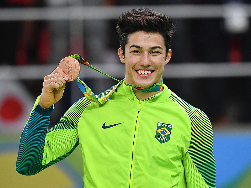 Brazil's Arthur Mariano celebrates on the podium of the men's floor event final of the Artistic Gymnastics at the Olympic Arena during the Rio 2016 Olympic Games in Rio de Janeiro on August 14, 2016. / AFP / Ben STANSALL (Photo credit should read BEN STANSALL/AFP/Getty Images)