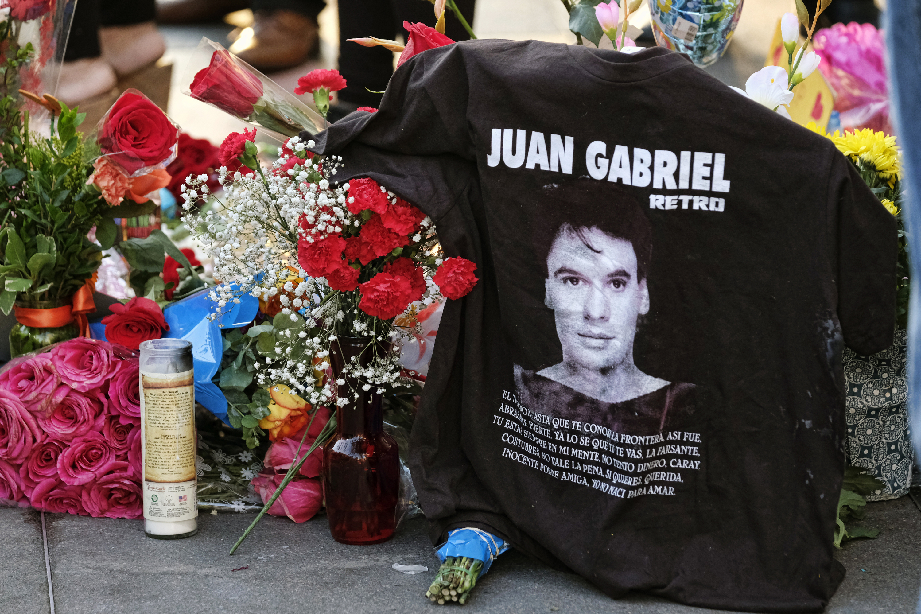Una camiseta, flores y velas rodean la estrella de Juan Gabriel en el Paseo de la Fama de Hollywood el lunes 29 de agosto del 2016, en Los Angeles. El cantante y compositor mexicano, un ícono de la música latina, murió el domingo en Santa Mónica, California. Tenía 66 años. (AP Foto/Richard Vogel)