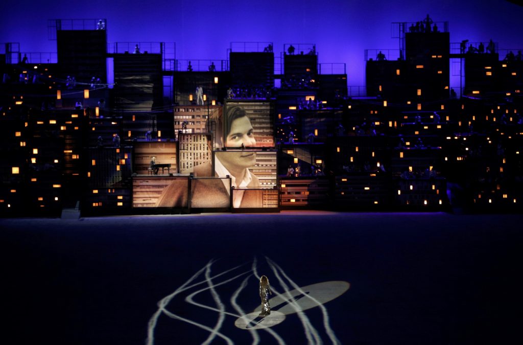 2016 Rio Olympics - Opening ceremony - Maracana - Rio de Janeiro, Brazil - 05/08/2016. Brazilian model Giselle Bundchen walks across the stage as an image of Brazilian composer Tom Jobim is seen projected on constructions meant to represent buildings. REUTERS/Brian Snyder TPX IMAGES OF THE DAY. FOR EDITORIAL USE ONLY. NOT FOR SALE FOR MARKETING OR ADVERTISING CAMPAIGNS.