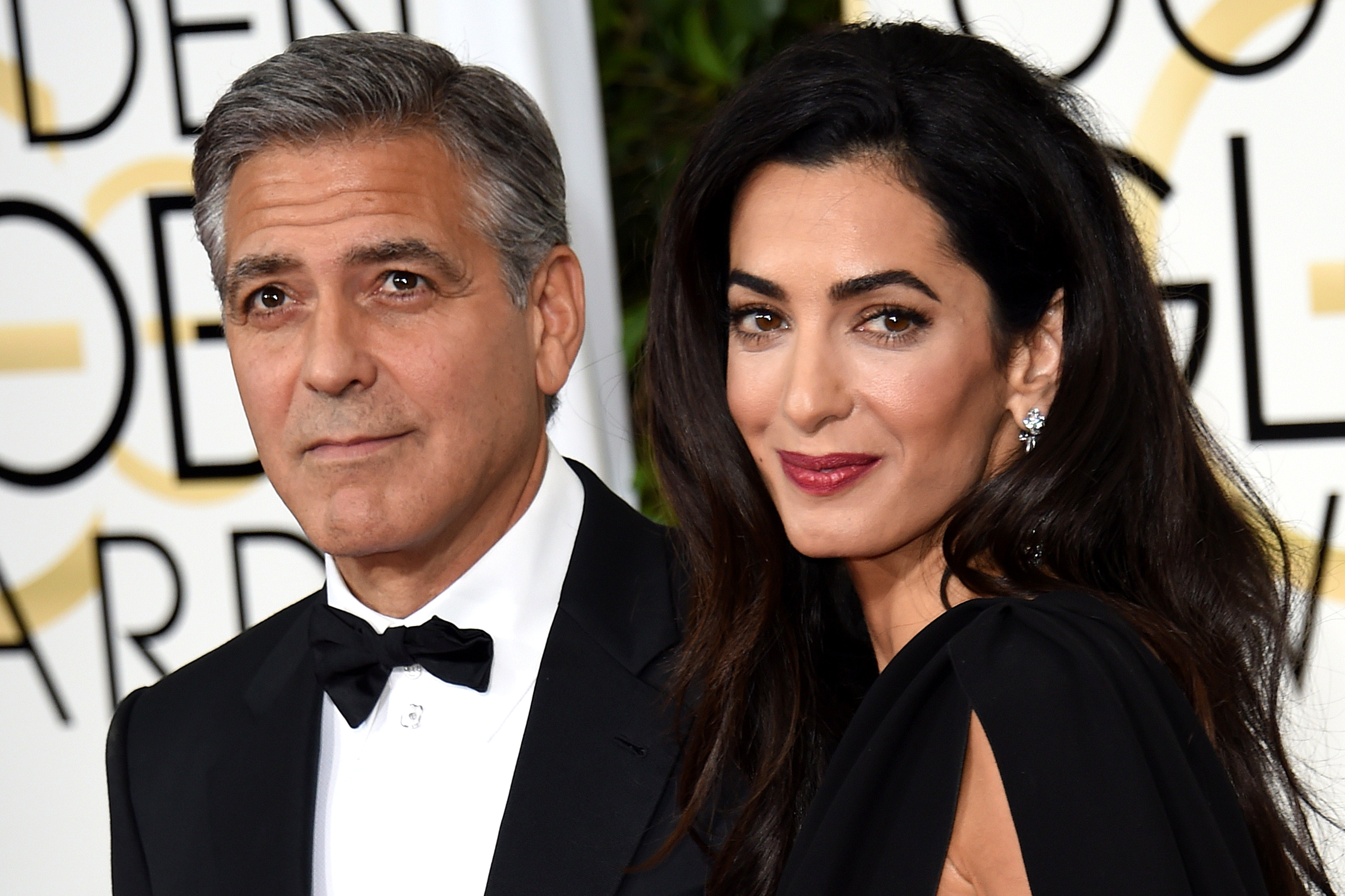 Actor George Clooney (L) and Amal Clooney arrive on the red carpet for the 72nd annual Golden Globe Awards, January 11, 2015 at the Beverly Hilton Hotel in Beverly Hills, California. AFP PHOTO/MARK RALSTONMARK RALSTON/AFP/Getty Images