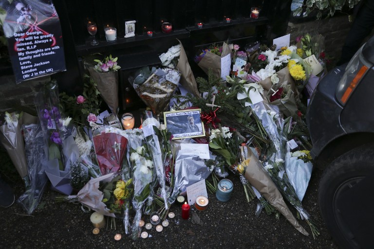 Messages and candles are seen among a pile of floral tributes outside the north London home of British singer George Michael on December 26, 2016, after news of the singer's death broke. Tributes poured in from the music world on December 26 after British pop superstar George Michael, who rose to fame with the duo Wham! and a string of smash hits including "Last Christmas", died aged 53. Michael died of apparent heart failure on Christmas Day at his home in Goring, a village on the River Thames in Oxfordshire, west of London, after an award-winning career spanning more than three decades. / AFP PHOTO / Daniel LEAL-OLIVAS