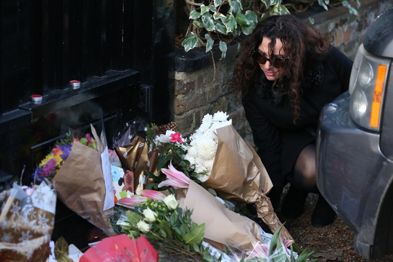 People lay bunches of flowers in tribute outside the north London home of British singer George Michael on December 26, 2016, after news of the singer's death broke.  Tributes poured in from the music world on December 26 after British pop superstar George Michael, who rose to fame with the duo Wham! and a string of smash hits including "Last Christmas", died aged 53. Michael died of apparent heart failure on Christmas Day at his home in Goring, a village on the River Thames in Oxfordshire, west of London, after an award-winning career spanning more than three decades. / AFP PHOTO / Daniel LEAL-OLIVAS