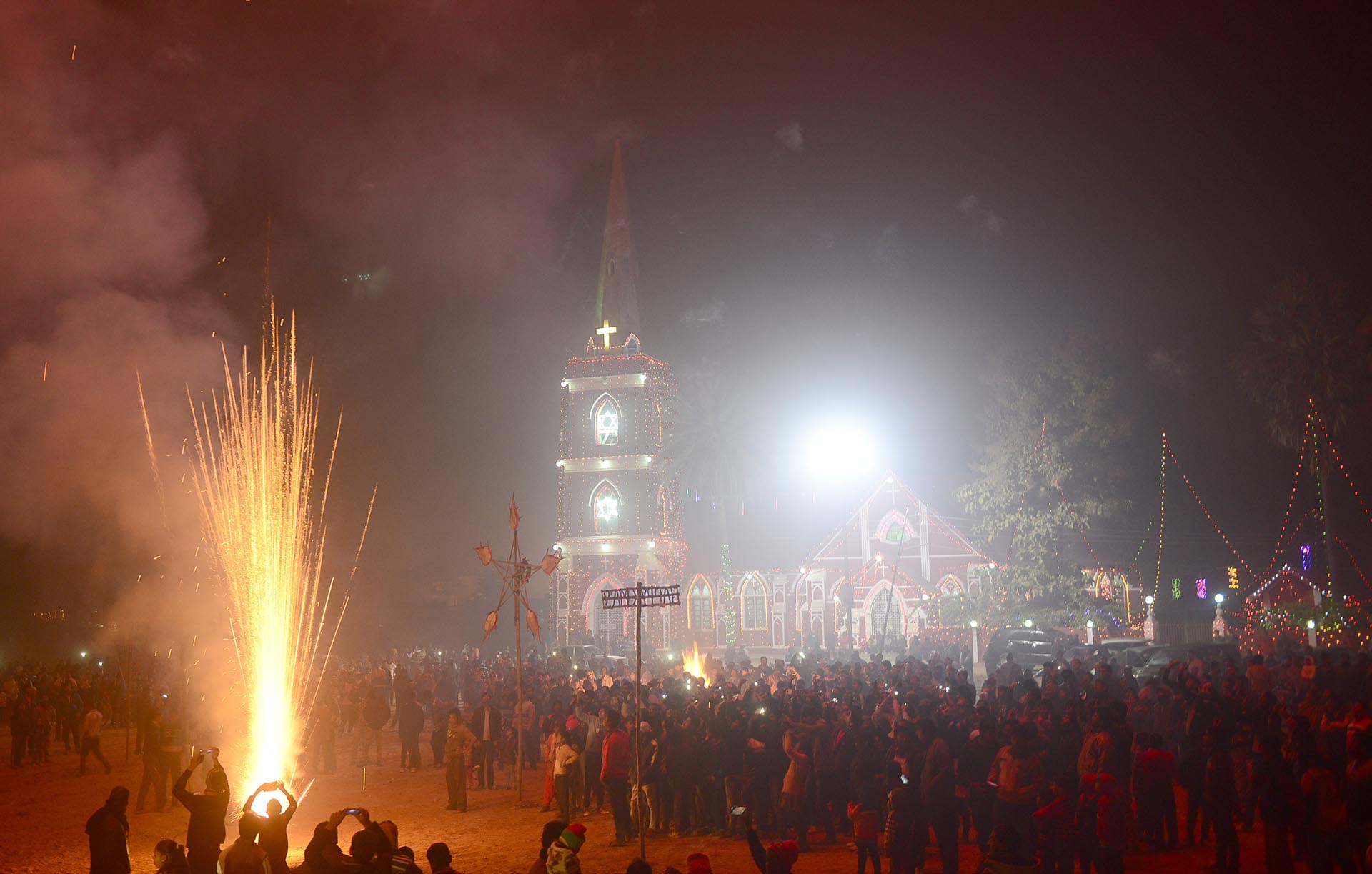 Indian Christian devotees watch a fireworks display marking Christmas Eve outside St. Peter's Church in Allahabad on December 24, 2016. / AFP PHOTO / SANJAY KANOJIA
