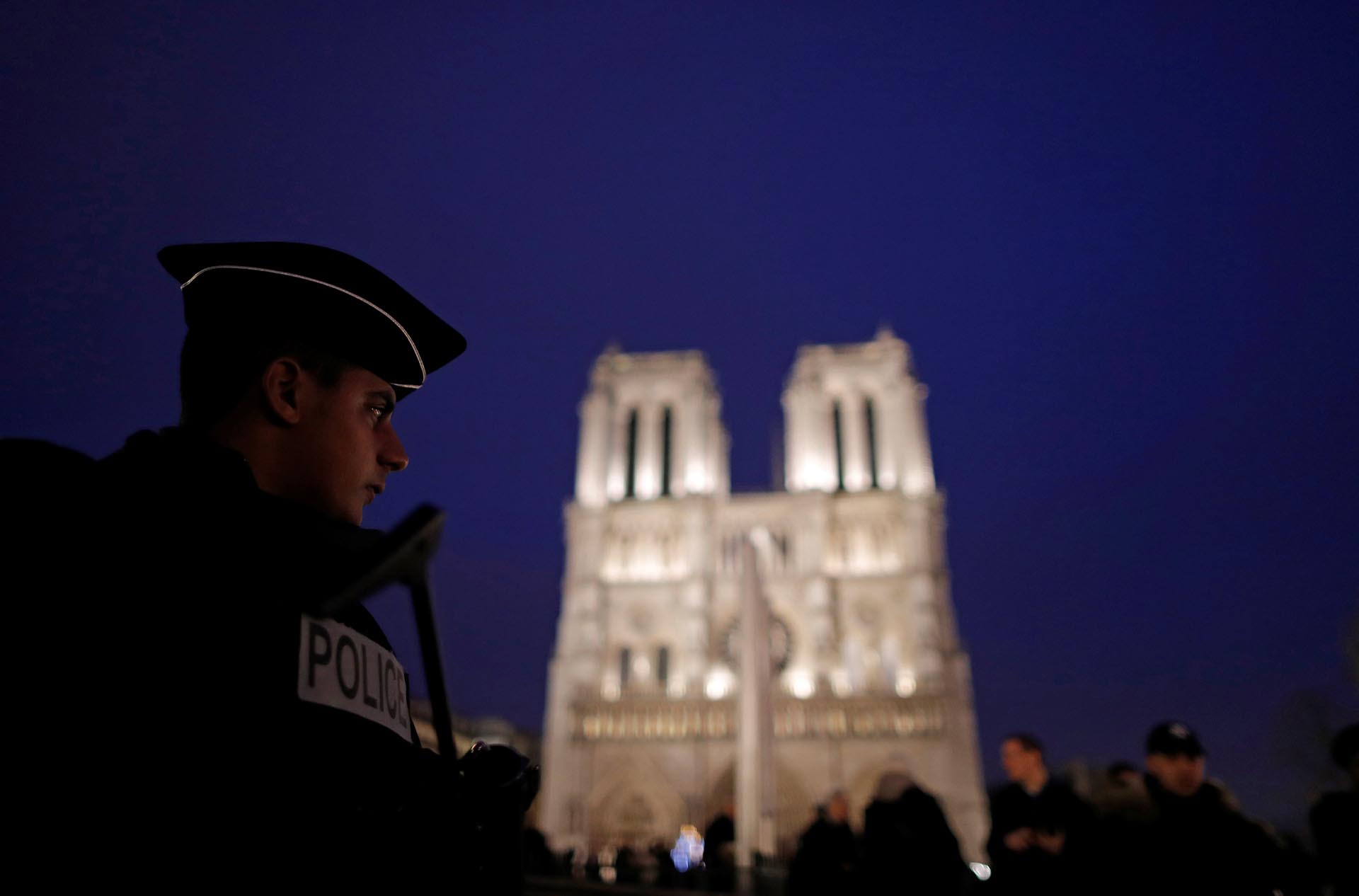 A French policemen stands guard as heavy police forces secure the access to Notre-Dame cathedral during Christmas celebrations in Paris, France, December 24, 2016. REUTERS/Christian Hartmann